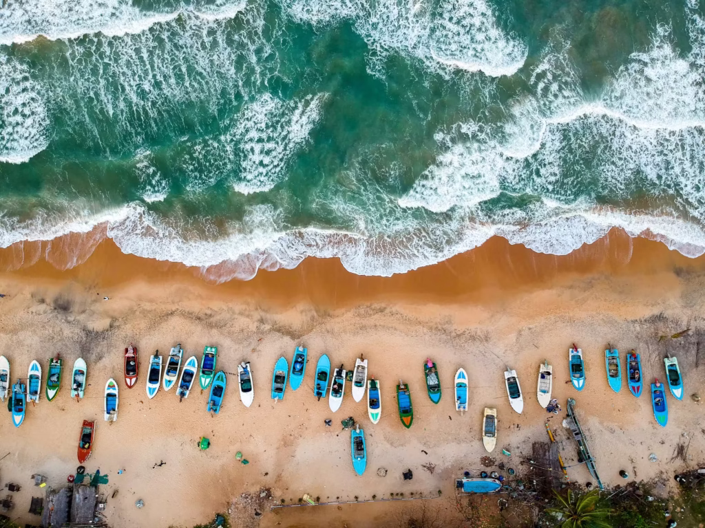 Surfers riding a long right-hand point break at Arugam Bay Main Point during the golden hour sunset. Arugam Bay Surf Guide. Best Sri Lanka Surf Guide - Surfer at Sunset.